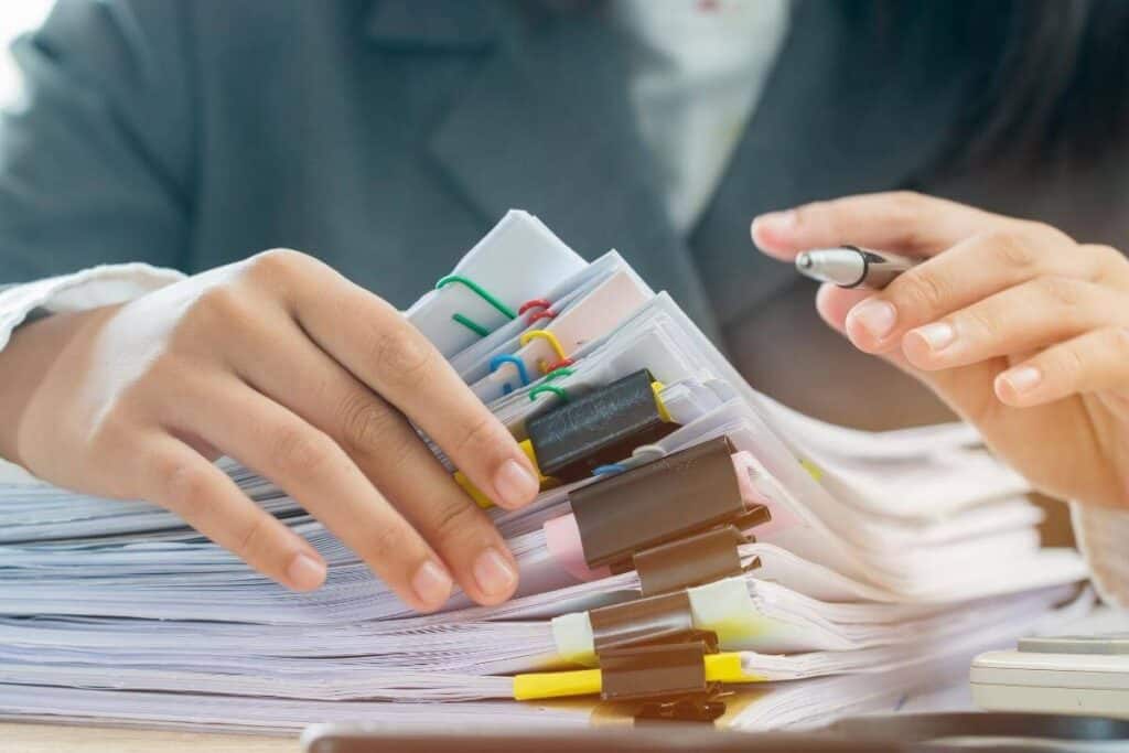 an auditor holding a stack of printed docutments